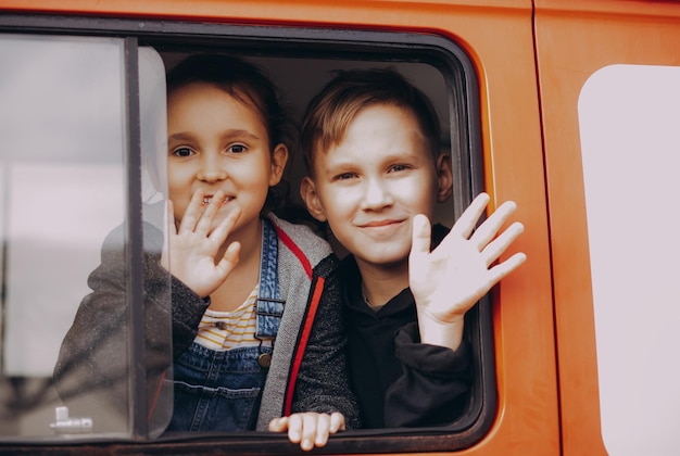 Foto bambini felici, fratello e sorella, viaggiano in macchina concetto di vacanza e viaggio