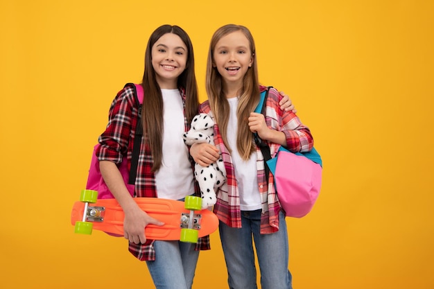 Happy kids in casual checkered shirt carry backpack toy and penny board casual lifestyle