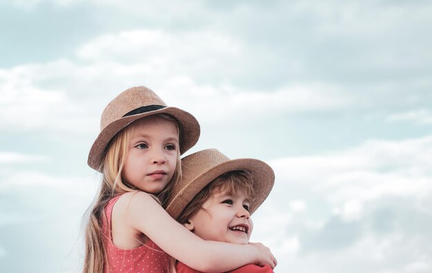 Happy kids embrace on blue sky background valentines day childhood on countryside cute little childr