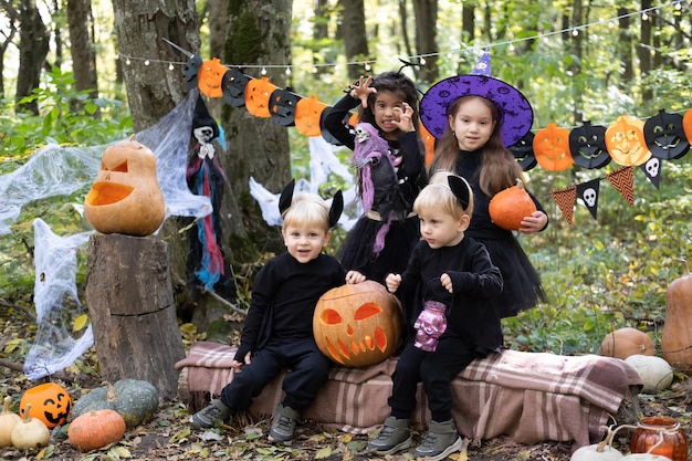 屋外のハロウィーンの装飾で楽しんでいるハロウィーンの衣装で幸せな子供たち