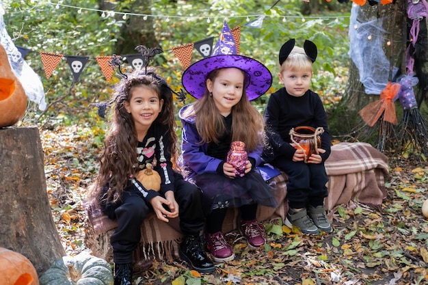 屋外のハロウィーンの装飾で楽しんでいるハロウィーンの衣装で幸せな子供たち