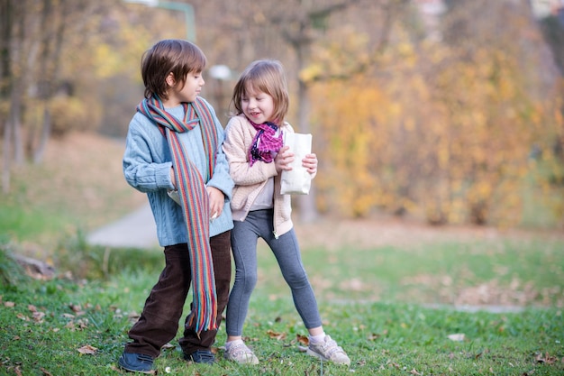 happy kids in park eating popcorn while having fun on beautyful autumn day