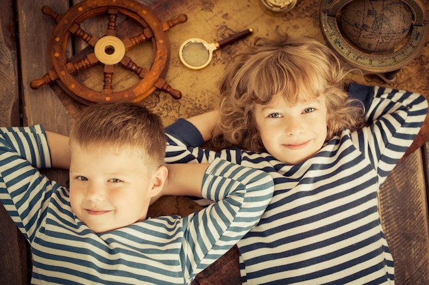 Счастливые дети играют с морскими вещами Дети веселятся дома Концепция путешествий и приключений Необычный портрет с высоким углом обзора