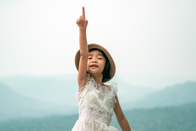 幸せな子供が空を指す