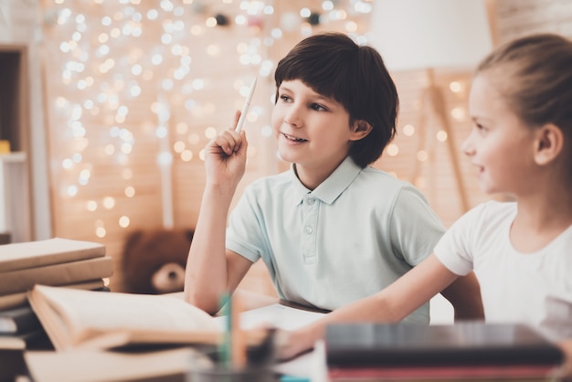 Happy Kids Prepare for Class Together at the Desk.