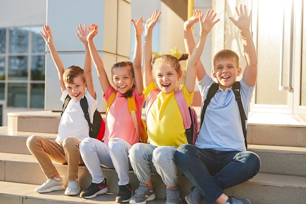 学校の階段に座っている幸せな子供たち