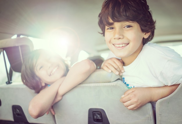 幸せな子供たちが車で旅行