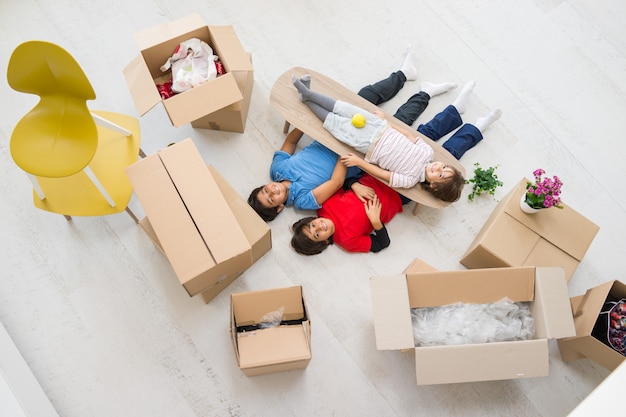 Happy kids with boxes at new modern home