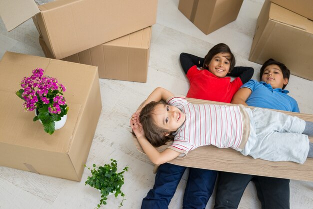 Happy kids with boxes at new modern home