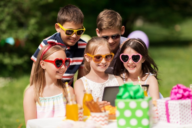 Photo happy kids with tablet pc on birthday party