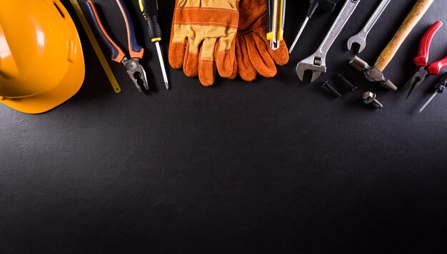 Happy Labor day concept. Different construction tools on dark wooden background.