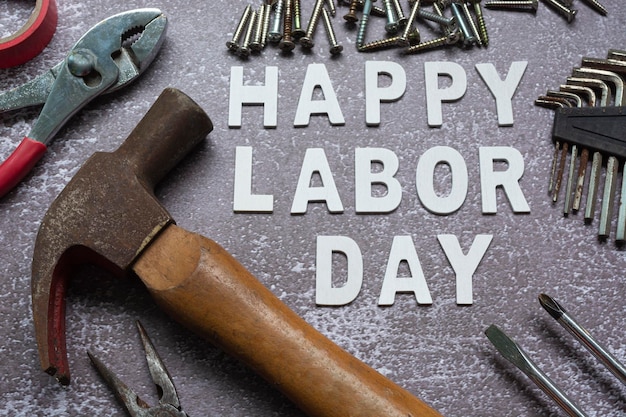 Happy labor day text with repair equipment and many handy tools on grunge grey concrete background