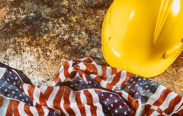 Happy Labor Day USA patriotic construction helmet USA flag over wooden deck table.