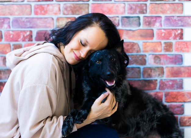 Photo happy lady in casual wear hugging purebred pet dog mudi with owner over studio background