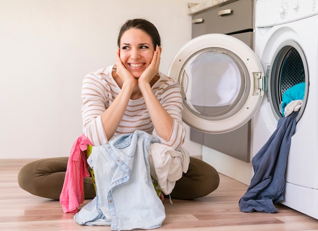 Happy lady doing laundry front view