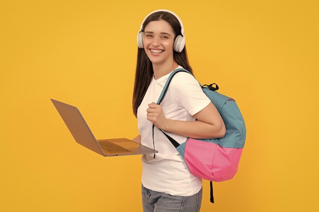 Happy lady in headphones using pc carry backpack communication