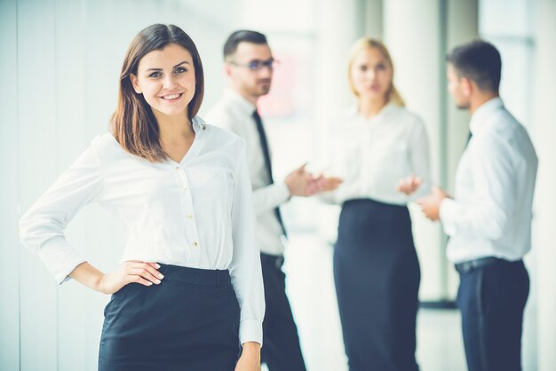 幸せな女性は同僚の近くに立っています