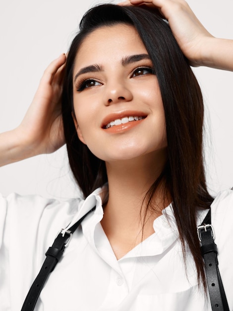 Happy lady with dark hair touching her head with hands closeup portrait