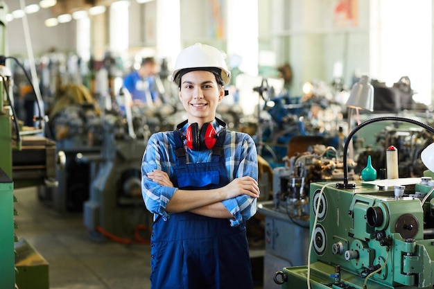 Happy lady worker against industrial machines