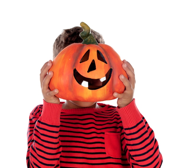 Happy latin boy holding a big pumpkin 