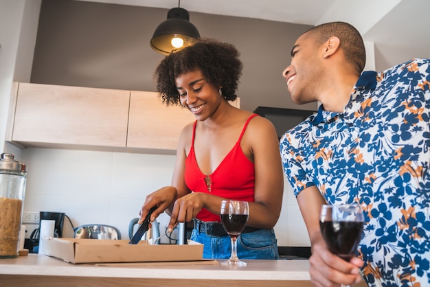 Happy latin couple having dinner at home.