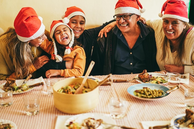 Happy latin family having fun eating together during Christmas time Soft focus on girl face