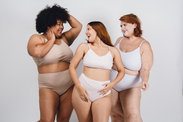 happy latin multi racial women smiling in underwear white background