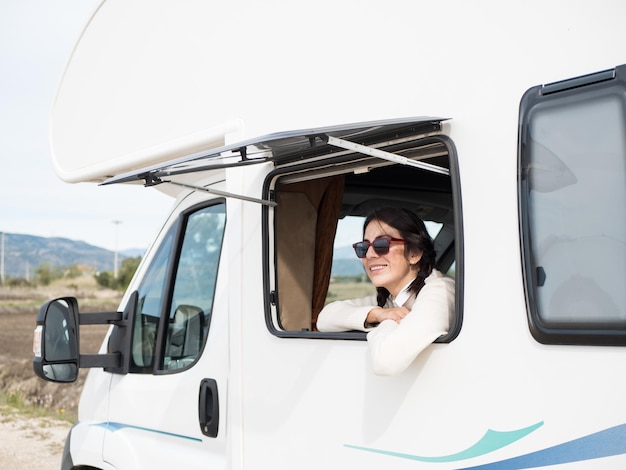 Happy latin woman looking out the motorhome window