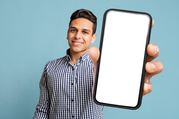 Happy Latino Man Showing Cell Phone With Empty Screen