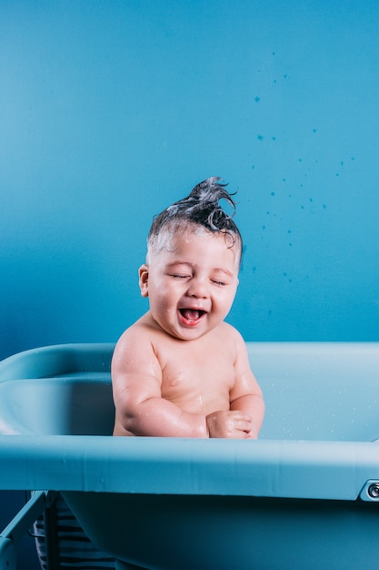 Happy laughing baby taking a bath Smiling kid in bathroom