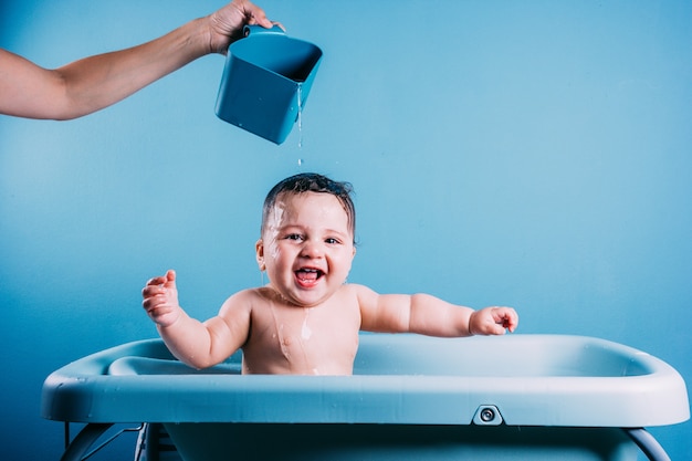 Happy laughing baby taking a bath