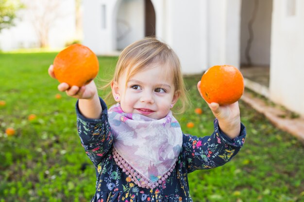 Happy laughing child playing with orange