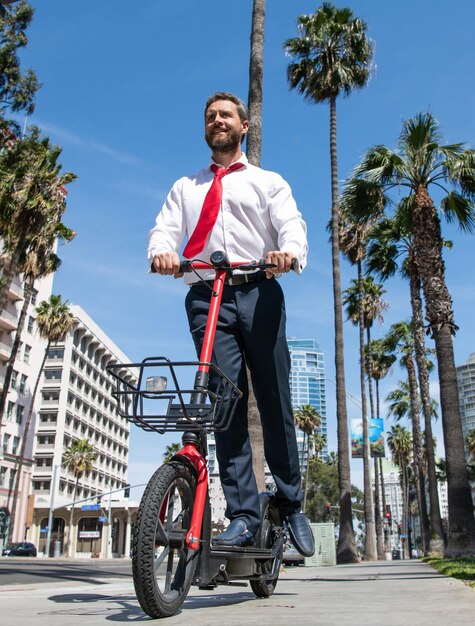 Happy lawyer in formalwear ride escooter on sidewalk riding