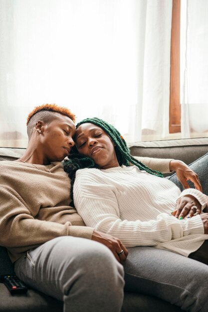 Happy lesbian couple asleep on the couch