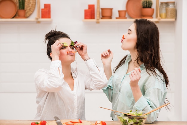 Coppie lesbiche felici che preparano alimento in cucina