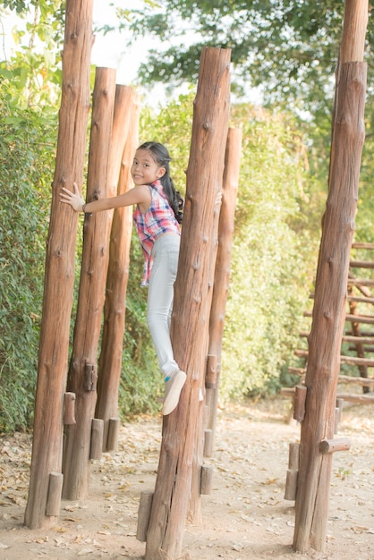 写真 幸せな小さなアジアの女の子の子供は笑顔で遊び場で遊んで楽しんでいて、健康的で面白い笑顔の愛らしい素敵な女性の子供を笑っています。