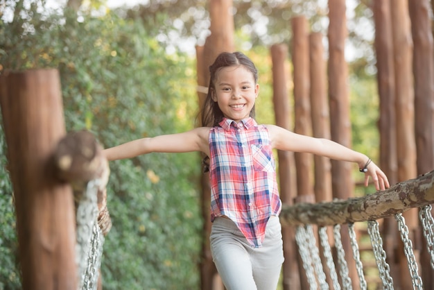 写真 幸せな小さなアジアの女の子の子供は笑顔で遊び場で遊んで楽しんでいて、健康的で面白い笑顔の愛らしい素敵な女性の子供を笑っています。