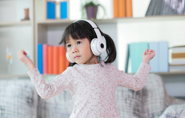 Happy little Asian girl listening to music