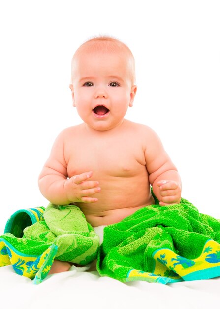 Happy little baby in groene handdoek op witte achtergrond.