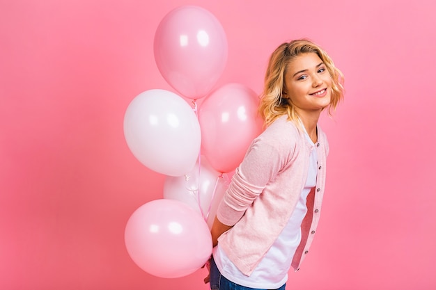 Happy little blonde girl with balloons celebrating holidays