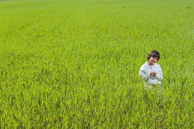 Foto ragazzino felice sul bello prato verde dell'erba gialla