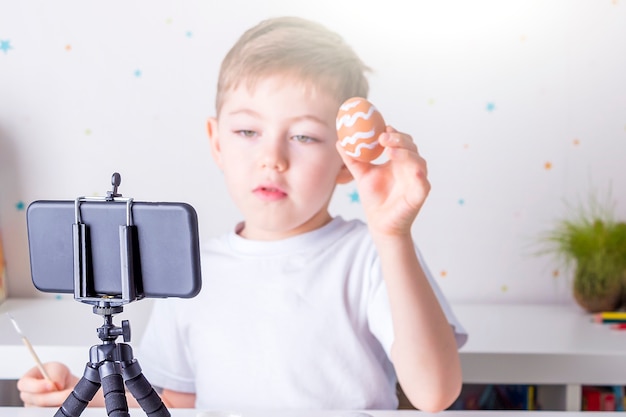 Happy little boy blogger recording live video streaming on smartphone