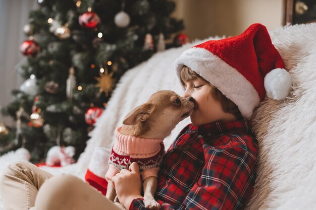 クリスマスに幸せな小さな男の子と犬