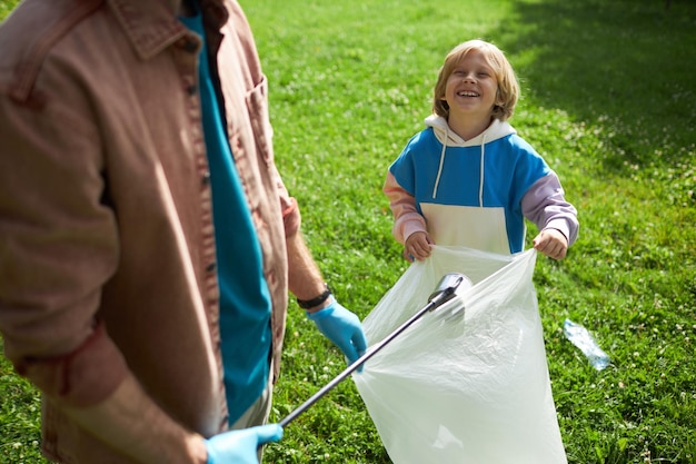 Happy little boy eco volunteering with dad in nature