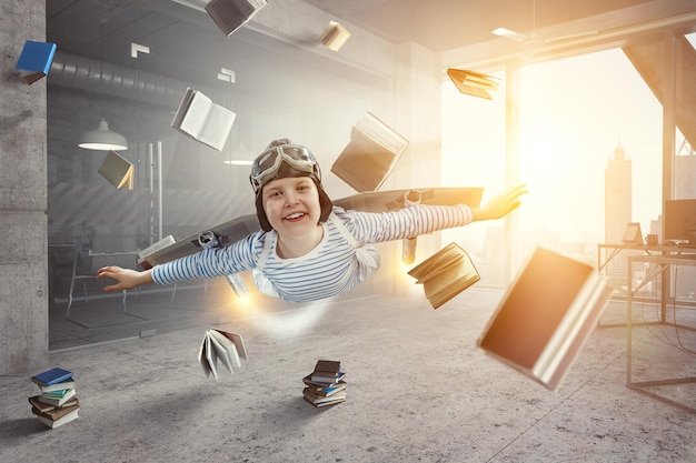 Photo happy little boy flying while wearing helmet. mixed media