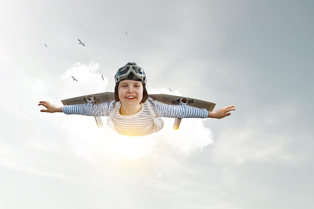 Photo happy little boy flying while wearing helmet. mixed media