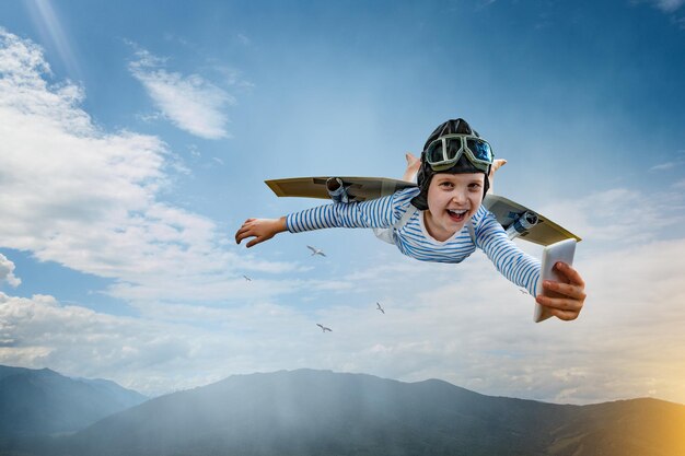 ヘルメットをかぶって飛んでいる幸せな少年。ミクストメディア