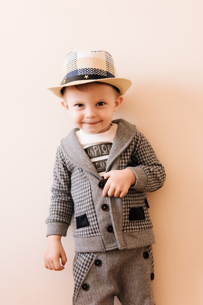 Foto ragazzino felice in un abito grigio con cappello