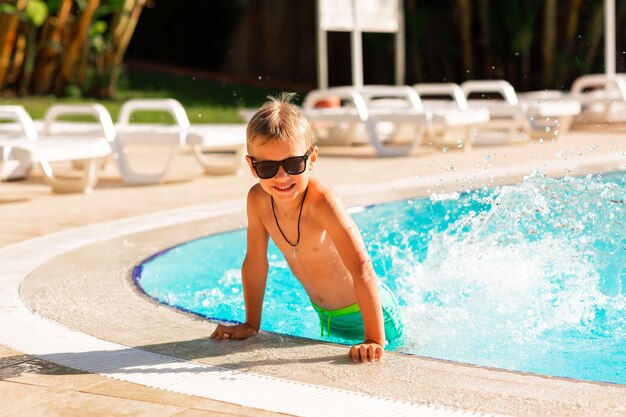 Happy little boy having fun at the pool at the resort