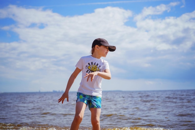 幸せな男の子は晴れた夏の日に海を走っています子供の頃のコンセプト